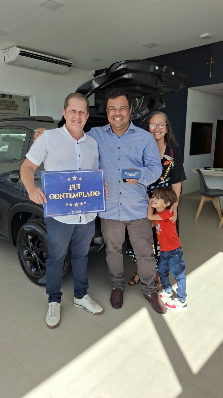 Diego Miranda com clientes contemplados durante uma entrega de veículo