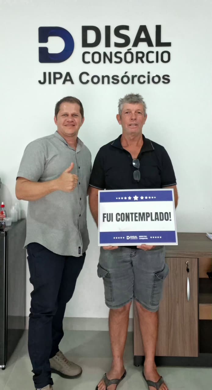 Cliente com certificado de contemplação ao lado de representante da JIPA